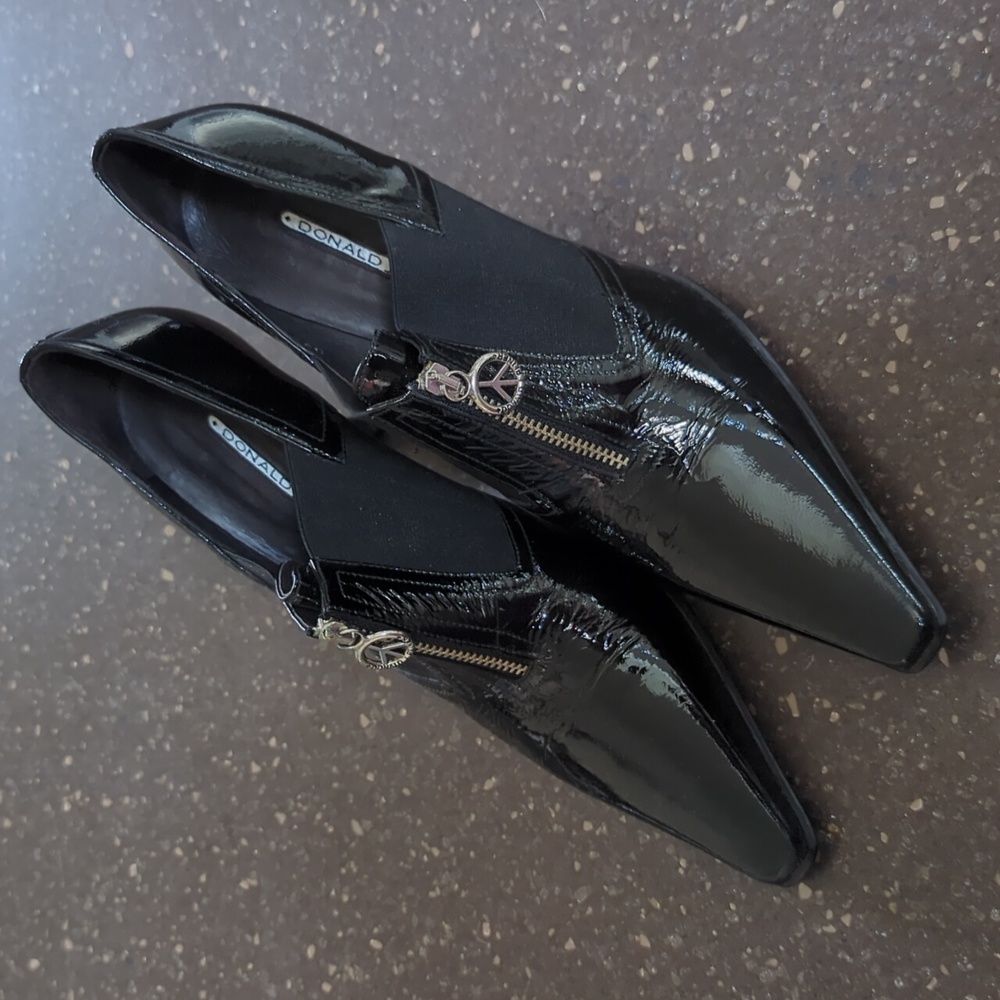 Black patent leather zip up Donald J Pliner heels, silver peace sign hardware